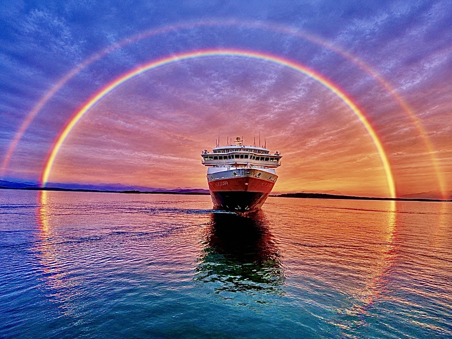 Mitternachtssonne mit Regenbogen.
